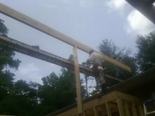 Carpenter setting a ridge beam over a new addition frame — Ice Dam Removal by Roofing Brothers in Becket