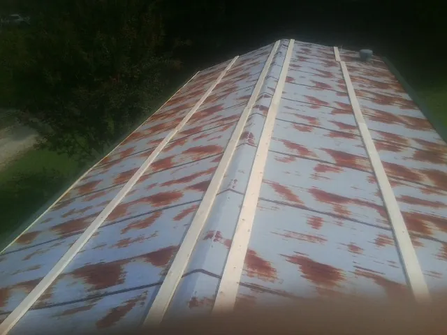 Rusted metal roof panels with new wood purlins before replacement — Storm Damage Roof Repair in Becket by Roofing Brothers