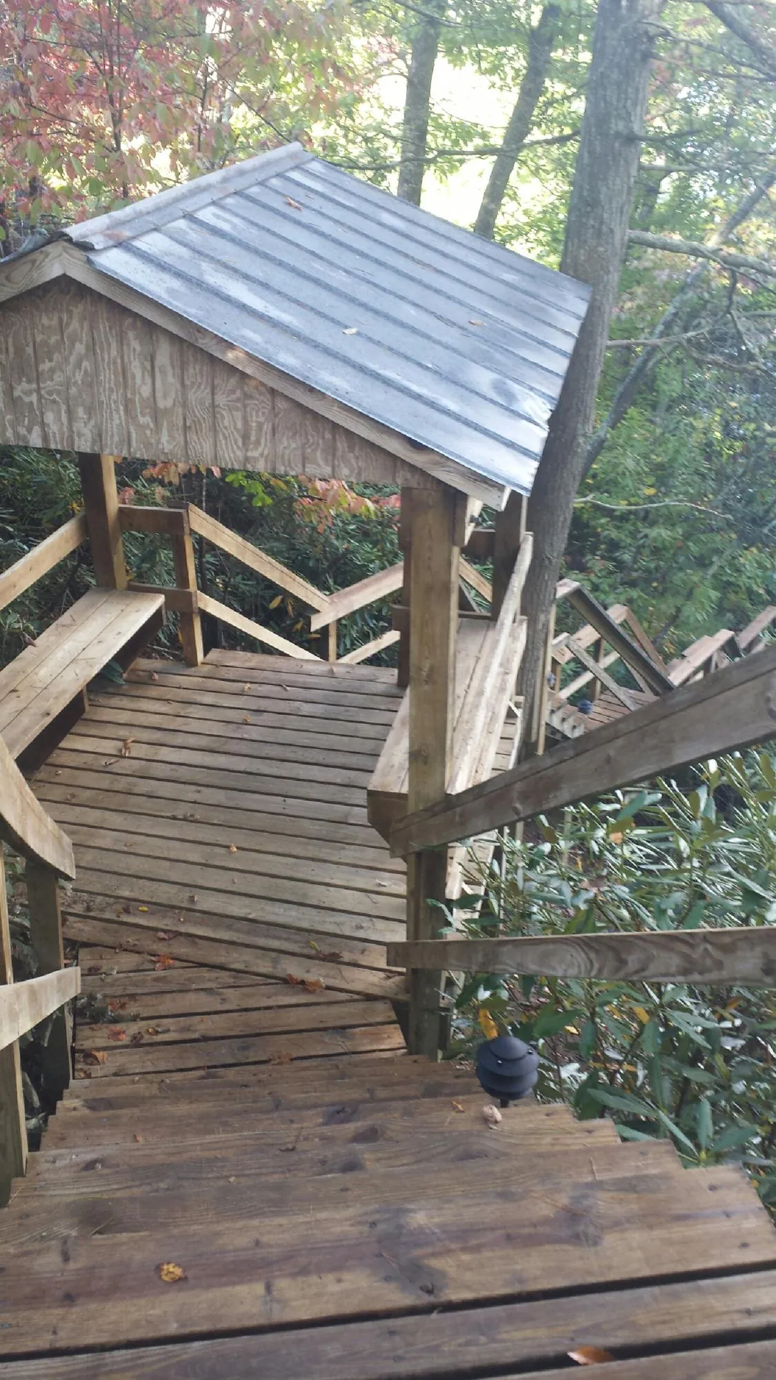 Metal roofed shelter over wooden steps on a wooded walkway — Skylight Repair & Installation work by our crew in Becket