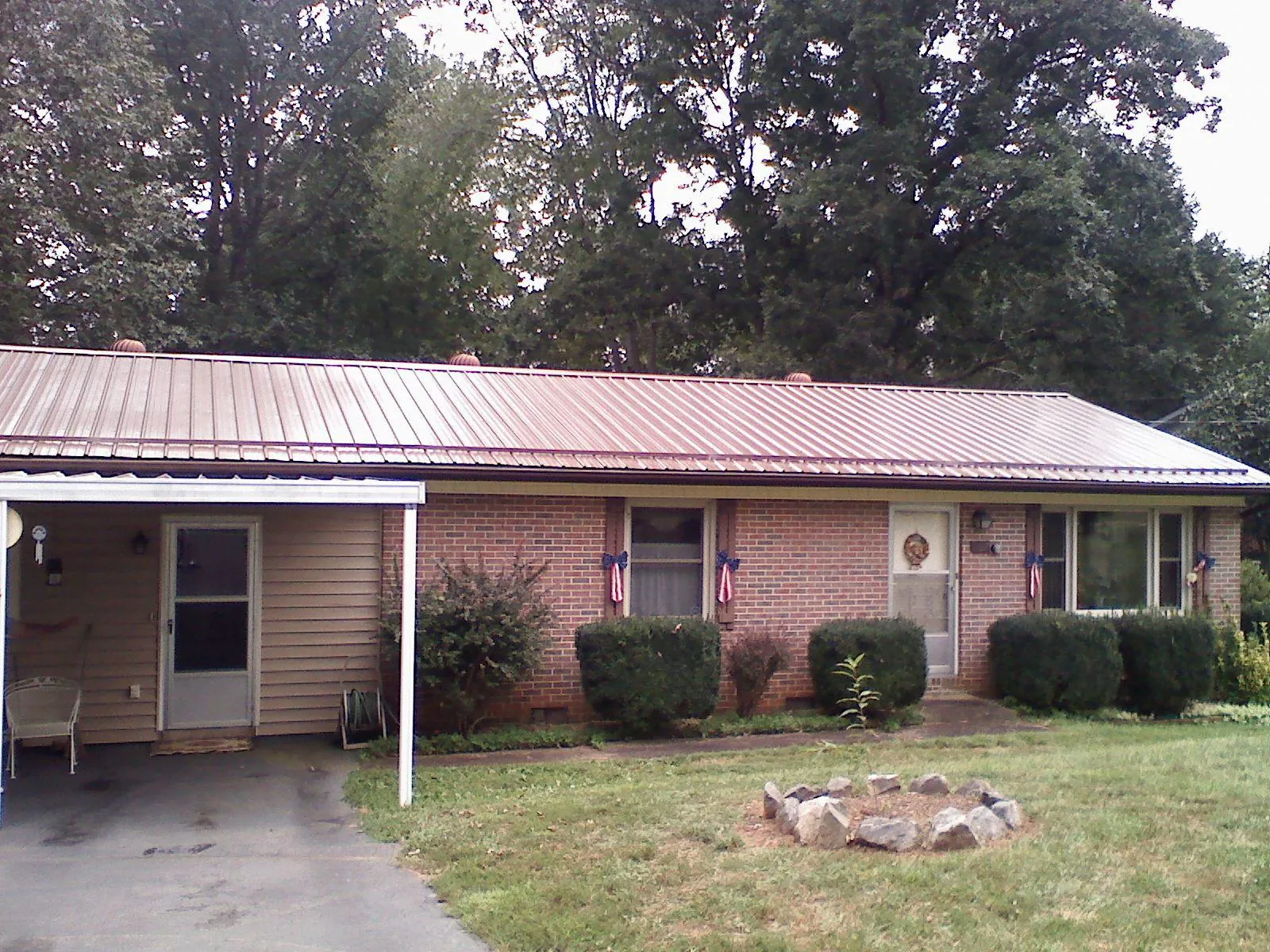 Bronze metal roof and carport on a brick ranch home — Roof Repair work by our crew in Becket